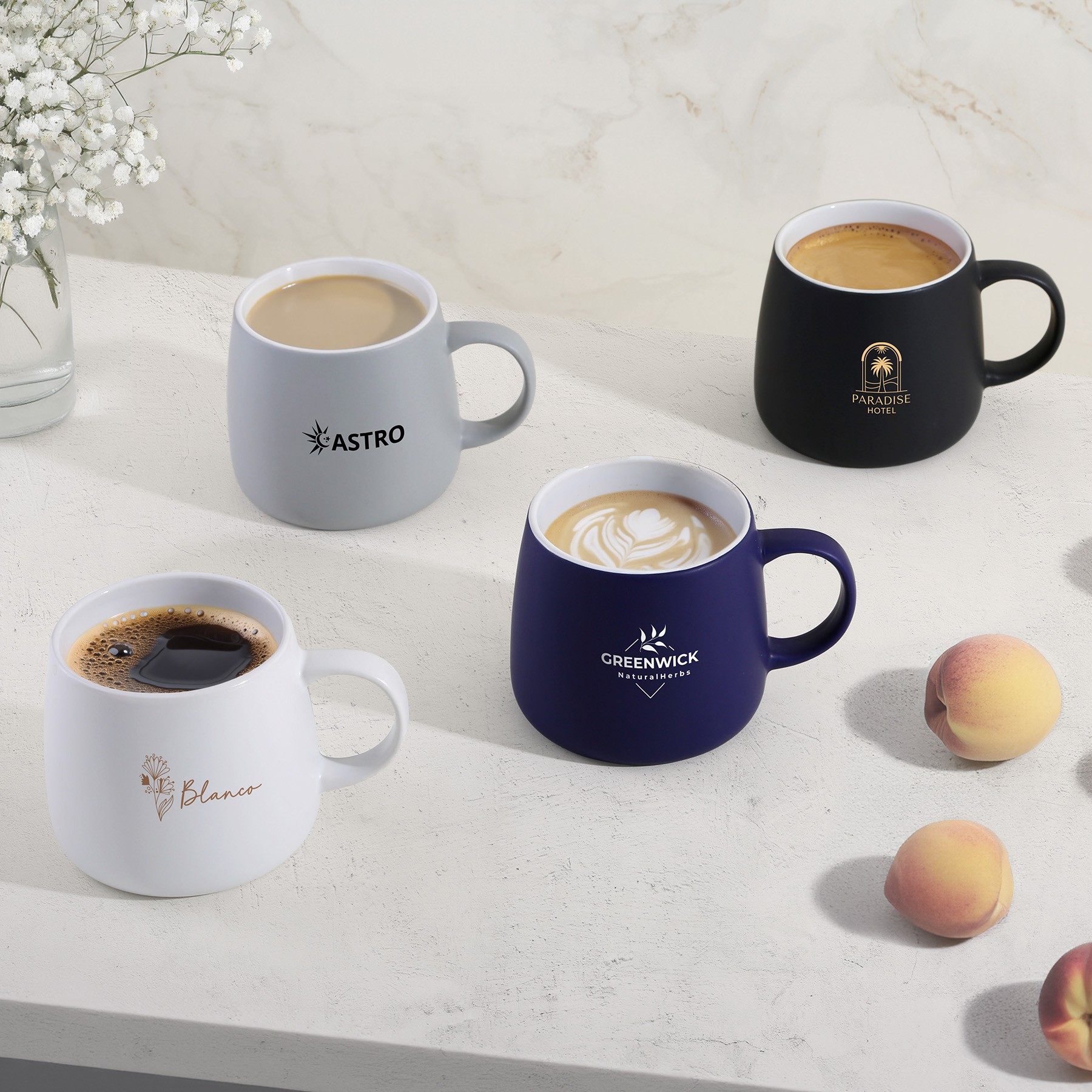 Branded ceramic mugs in assorted colors with cookies and coffee.