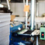 printing machine and large stack of brochures