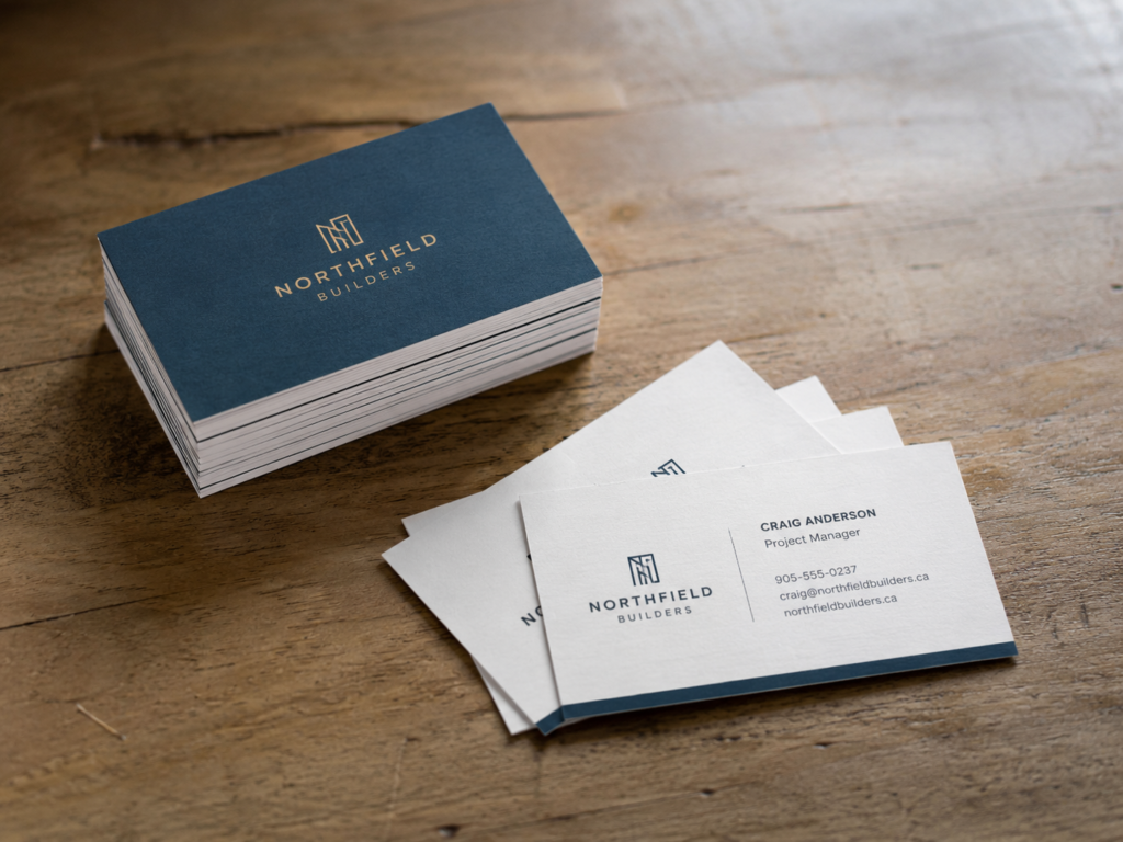 Professionally printed business cards in matte and premium finishes displayed on a wooden desk.